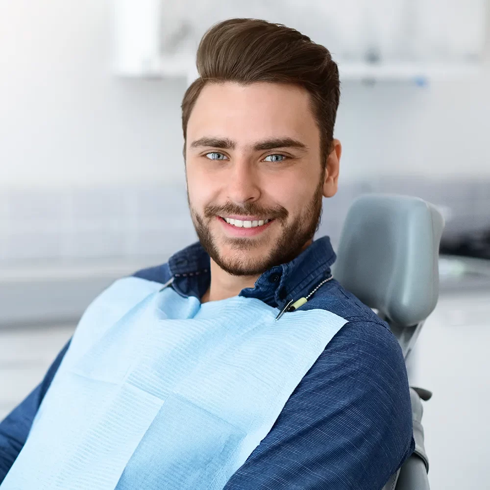 Confident male patient wearing dental bib and smiling at Onyx Dentistry cosmetic and family dentist in Vaughan
