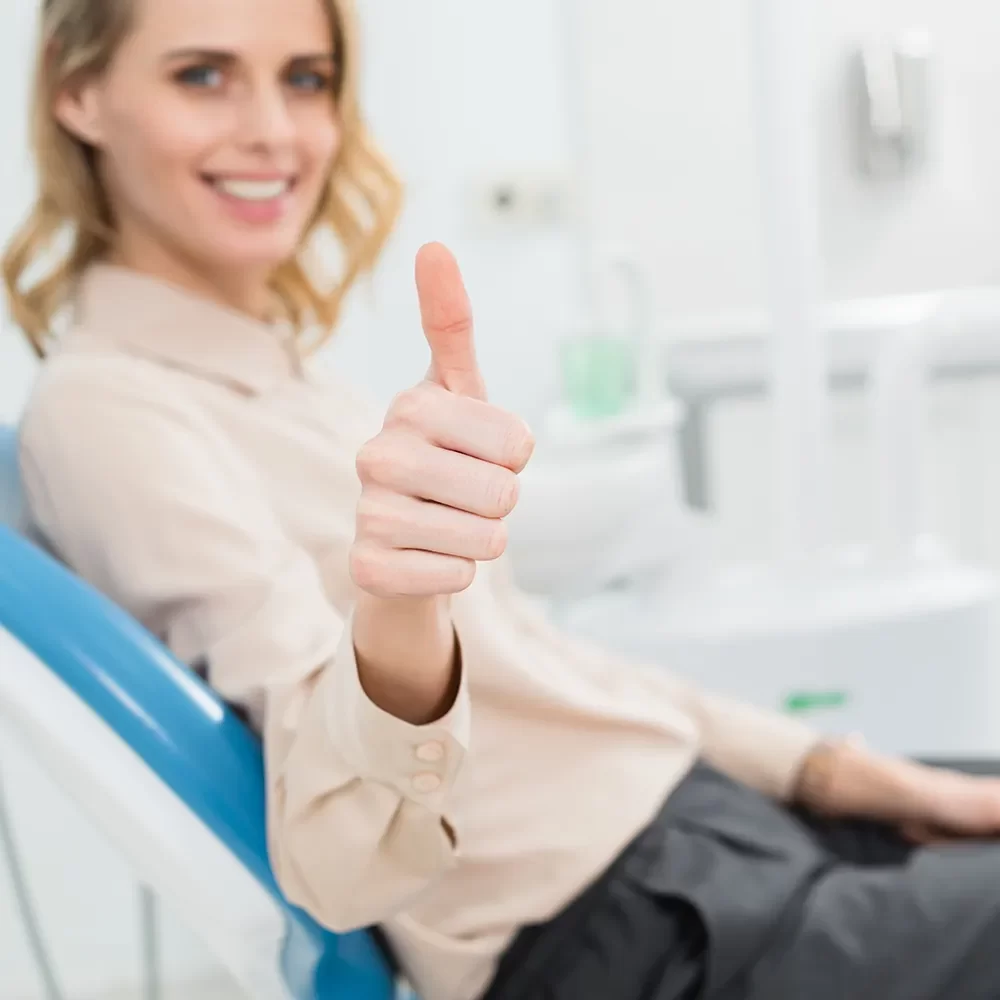 Smiling woman in dental chair showing thumbs up for excellent care at Onyx Dentistry clinic in Vaughan, Ontario